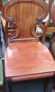 A late Victorian mahogany hall chair having shield back, solid seat and sabre legs.