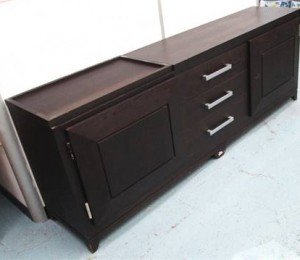Sideboard with three central drawers flanked by cupboards enclosing shelves.